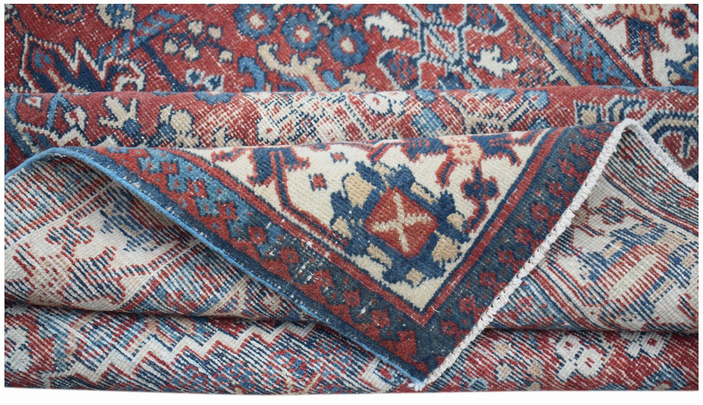 A vintage handwoven Persian Ghashghai rug featuring a traditional geometric pattern in red and blue.