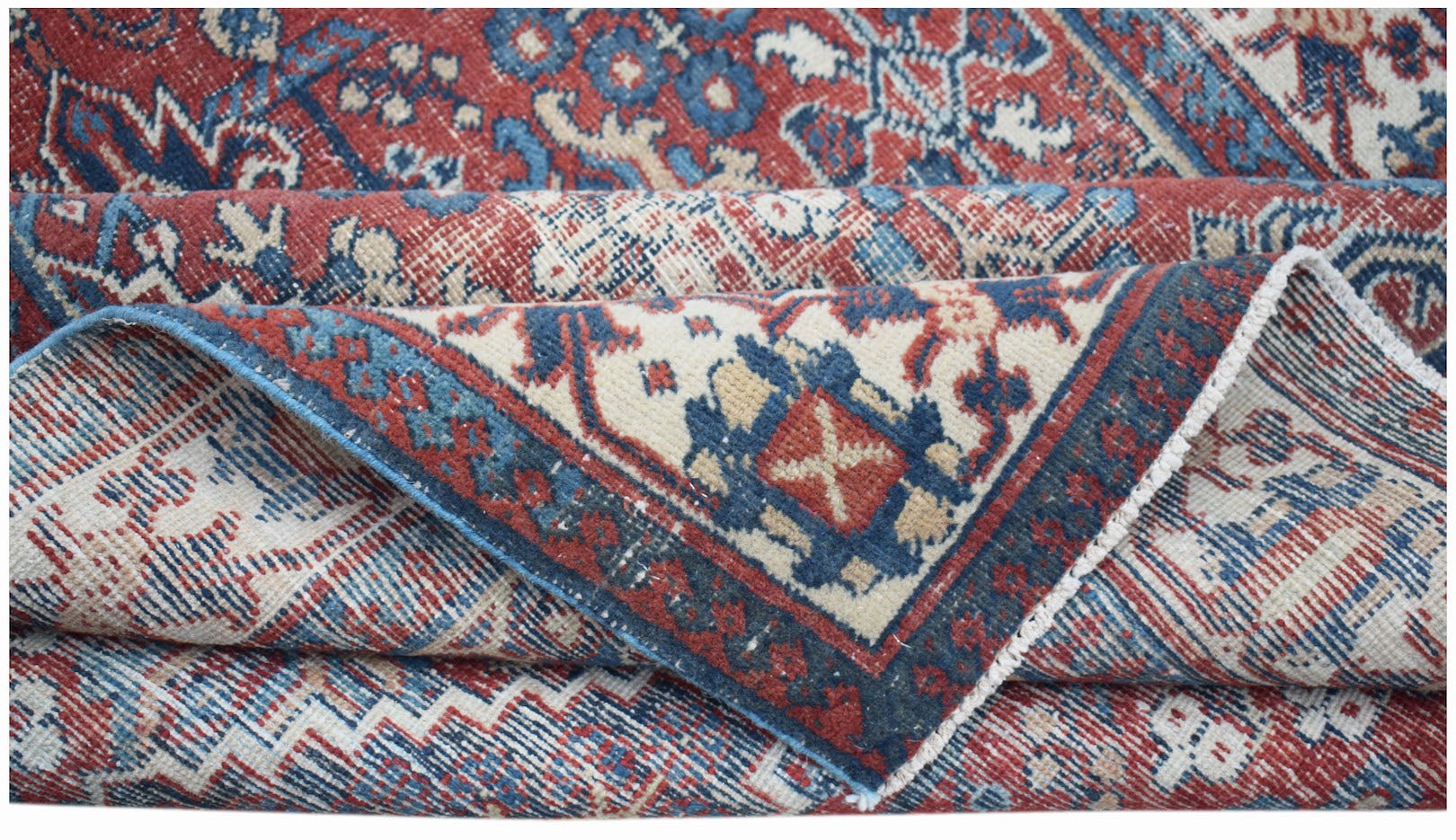 A vintage handwoven Persian Ghashghai rug featuring a traditional geometric pattern in red and blue.