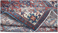 A vintage handwoven Persian Ghashghai rug featuring a traditional geometric pattern in red and blue.