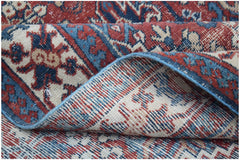 A handwoven vintage Persian Ghashghai rug featuring a traditional red and blue geometric pattern.