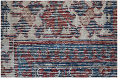 A close-up of a vintage Persian Ghashghai rug featuring intricate red and blue geometric patterns.