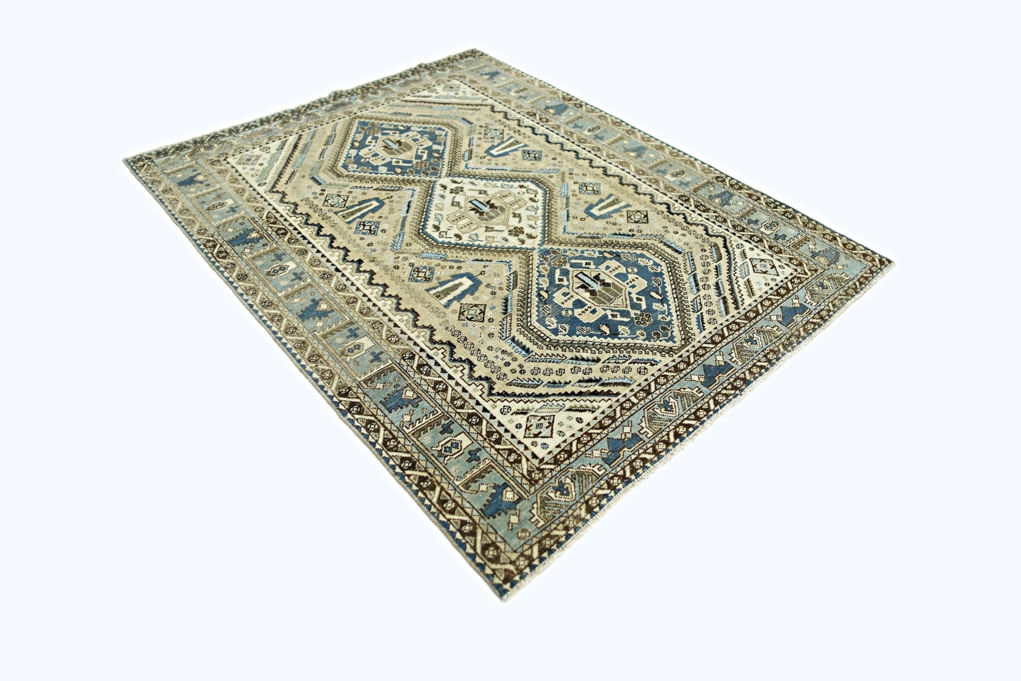 A vintage Persian Shiraz rug featuring geometric patterns in shades of blue, brown, and cream.