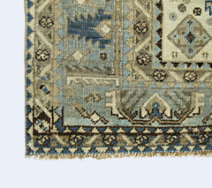 A vintage Persian Shiraz rug featuring intricate geometric patterns in blue and beige tones.