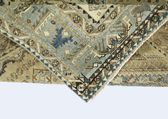 A folded vintage Persian Shiraz rug featuring intricate geometric patterns in blue and beige tones.