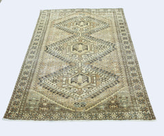 A vintage Persian Qashqai rug featuring a geometric diamond pattern in neutral earth tones.