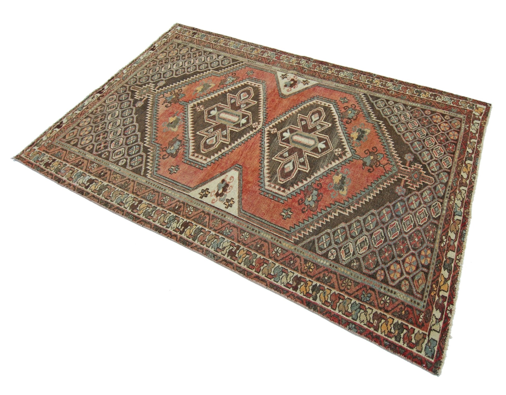 A handmade vintage Persian rug featuring geometric patterns in shades of brown and terracotta.