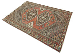 A handmade vintage Persian rug featuring geometric patterns in shades of red, brown, and cream.