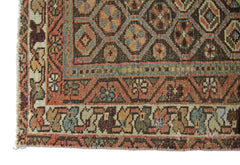 A vintage Persian rug featuring a geometric diamond pattern in muted earth tones.