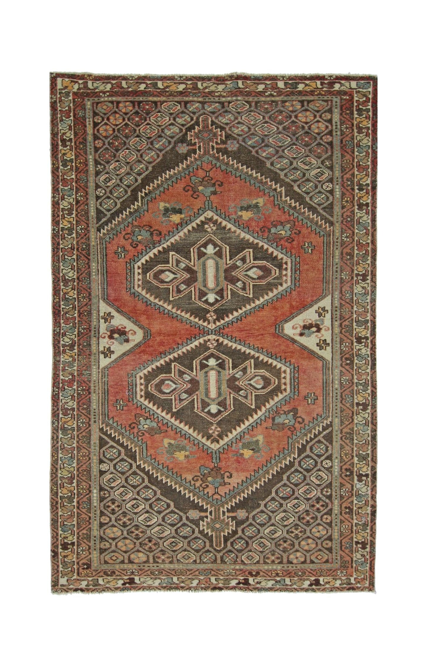 A vintage handmade Persian rug featuring a geometric diamond pattern in red and brown tones.