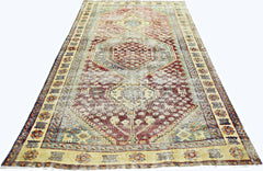 A vintage Persian Qashqai rug featuring a geometric medallion pattern in red, blue, and cream.
