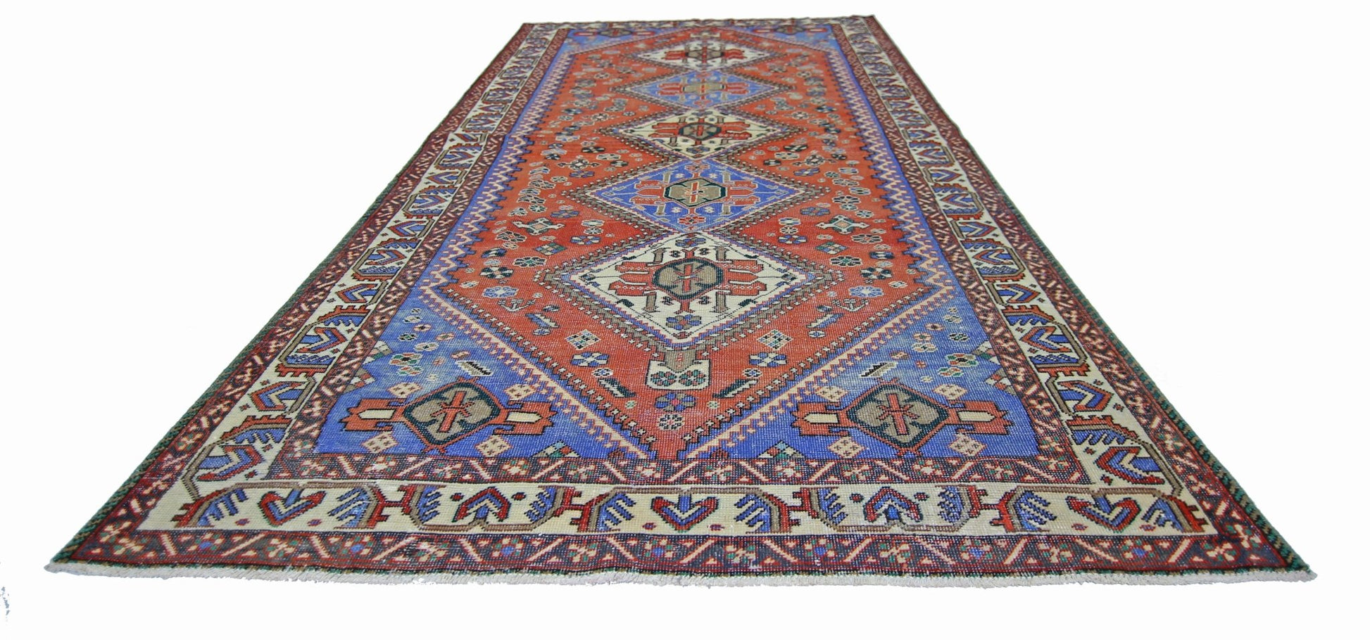 A vintage Persian Ghashghai rug featuring a geometric diamond pattern in red and blue tones.