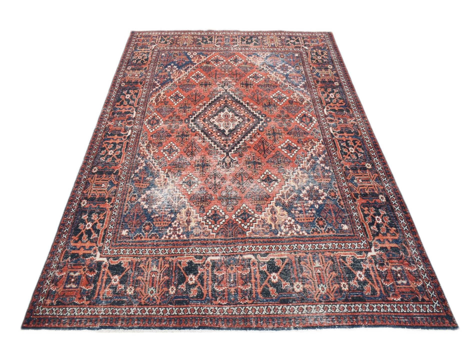 A vintage handwoven Persian Ghashghai rug featuring a geometric diamond pattern in red and blue.