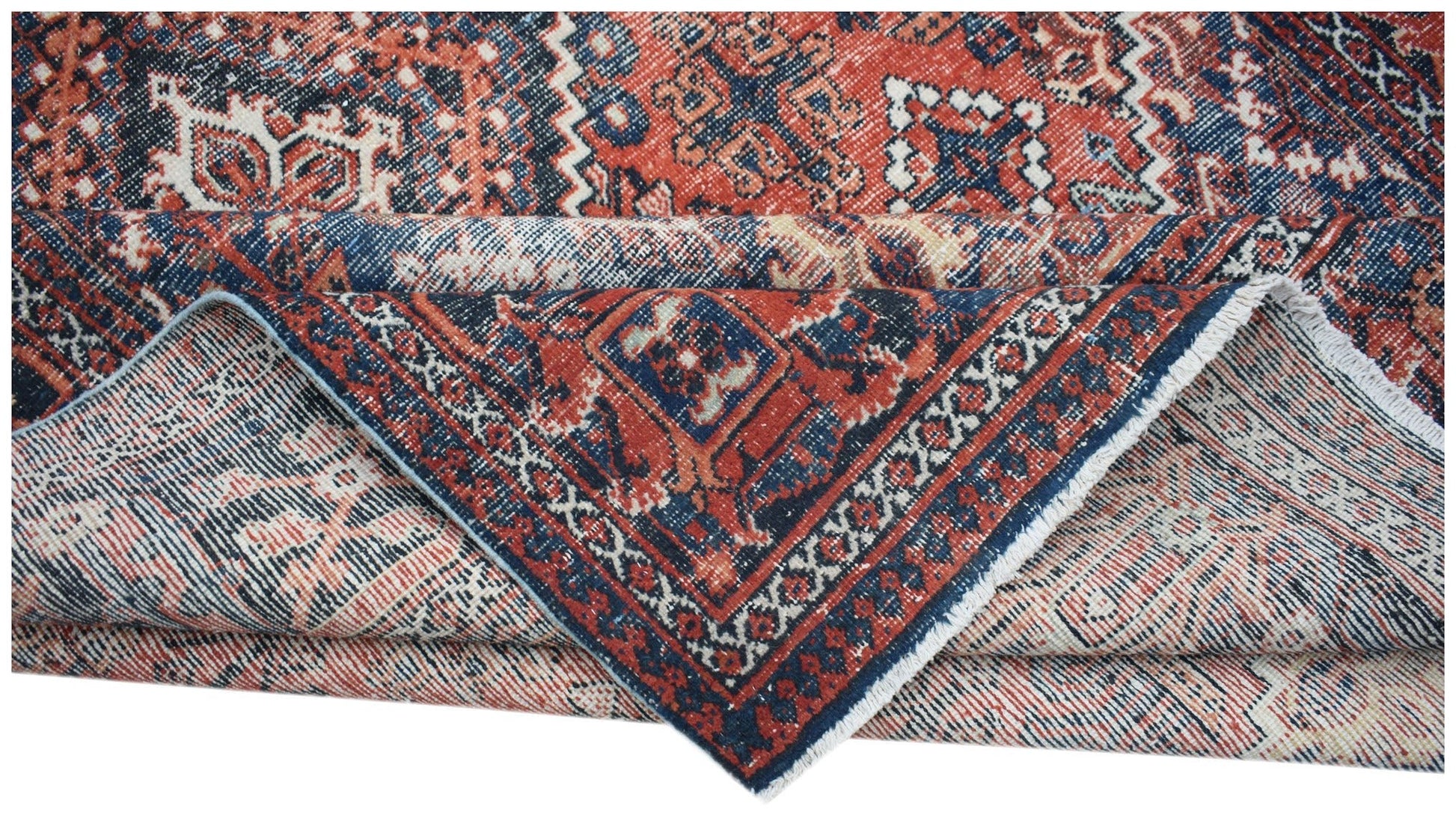 A vintage handwoven Persian Ghashghai rug featuring a geometric pattern in red and blue tones.