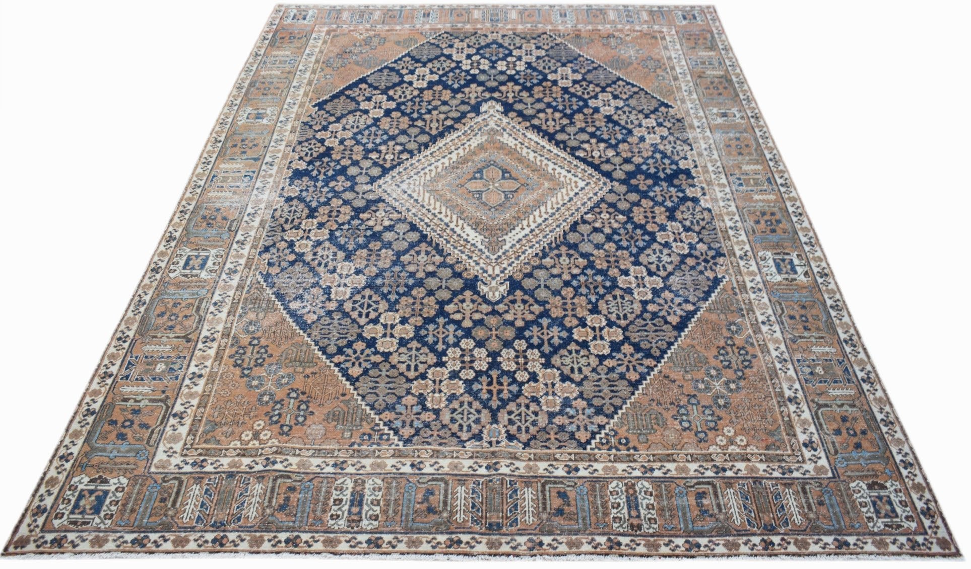Vintage Persian Ghashghai rug featuring a central diamond medallion in blue and tan wool.