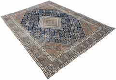 A vintage Persian Ghashghai rug featuring a central diamond medallion on a blue and brown field.