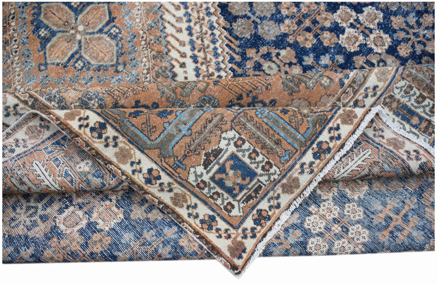 A vintage Persian Ghashghai rug featuring intricate geometric patterns in blue and terracotta tones.