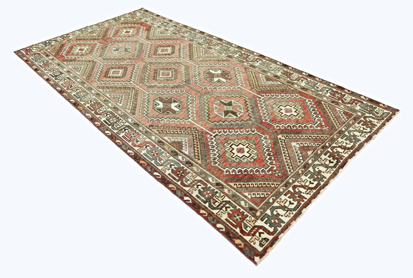 A rectangular vintage Persian rug featuring a geometric diamond pattern in shades of red and grey.