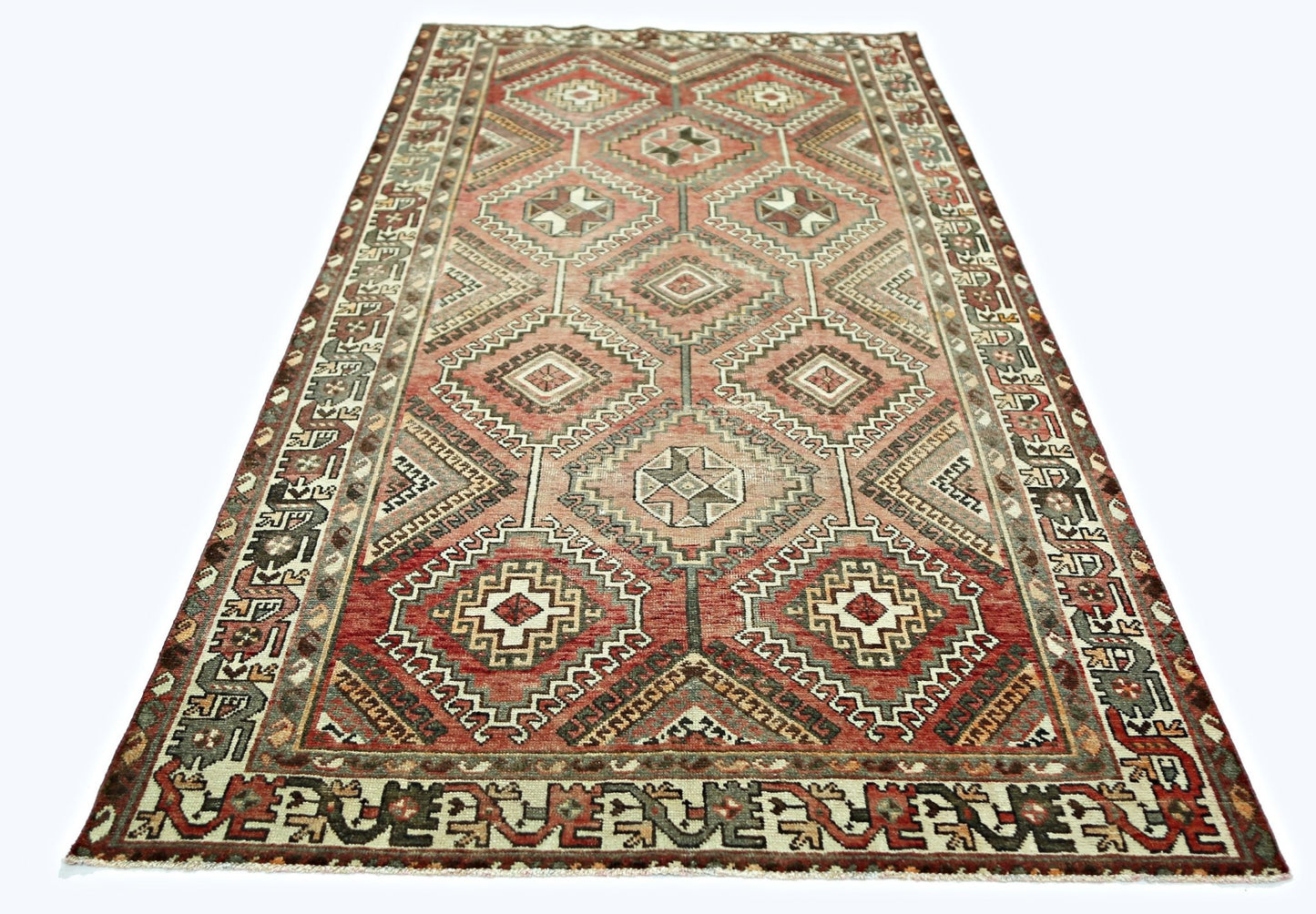 A handmade vintage Persian rug featuring a geometric diamond pattern in shades of red and brown.