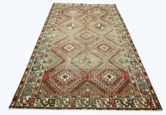 A handmade vintage Persian rug featuring a geometric diamond pattern in shades of red and brown.