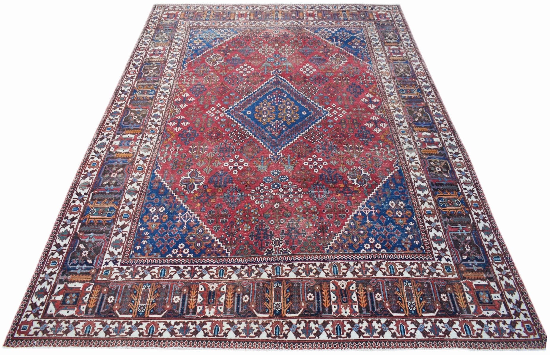 A vintage Persian Ghashghai rug featuring a red field with a blue central medallion and borders.