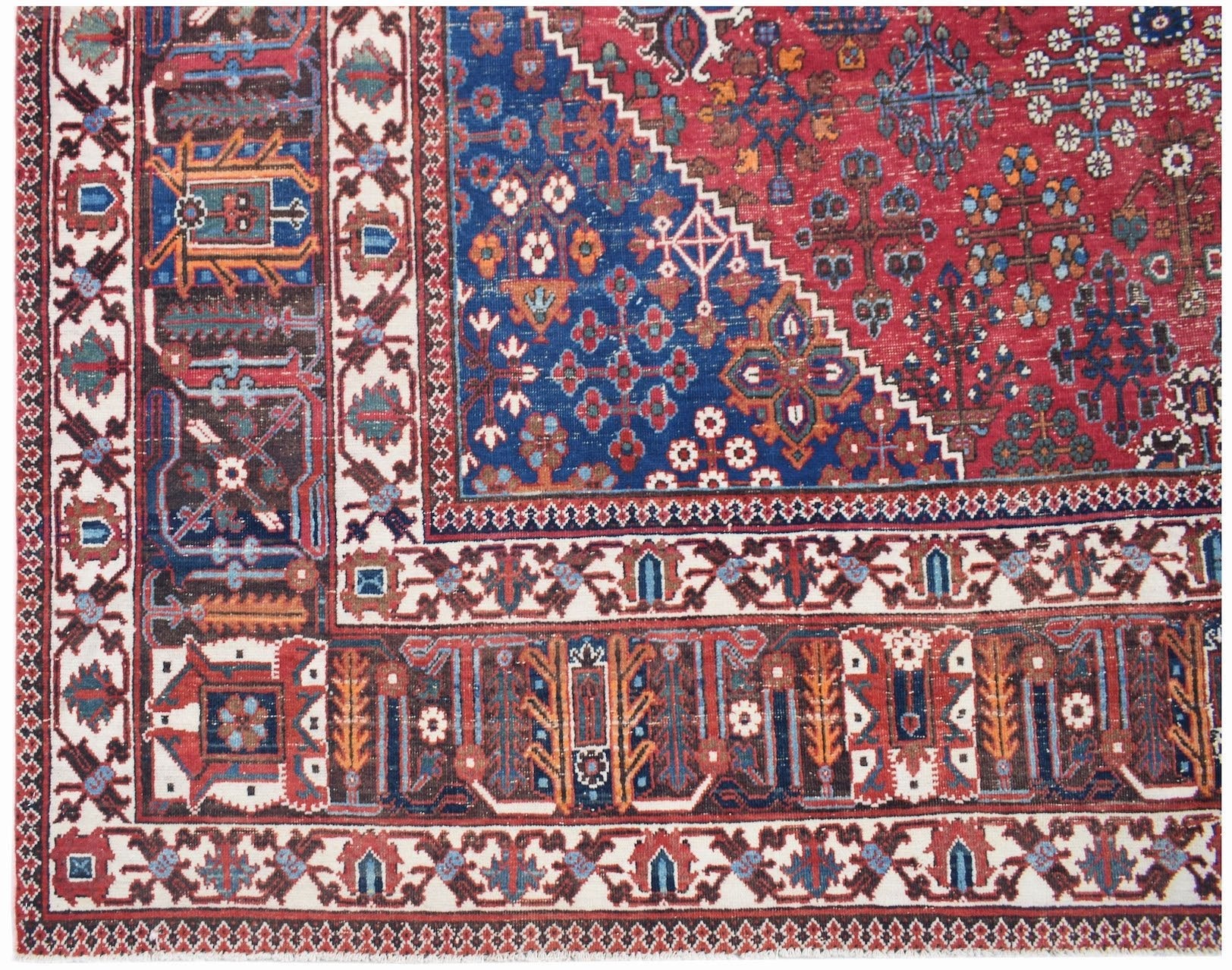 A vintage handwoven Persian Ghashghai rug featuring intricate geometric patterns in red and blue.
