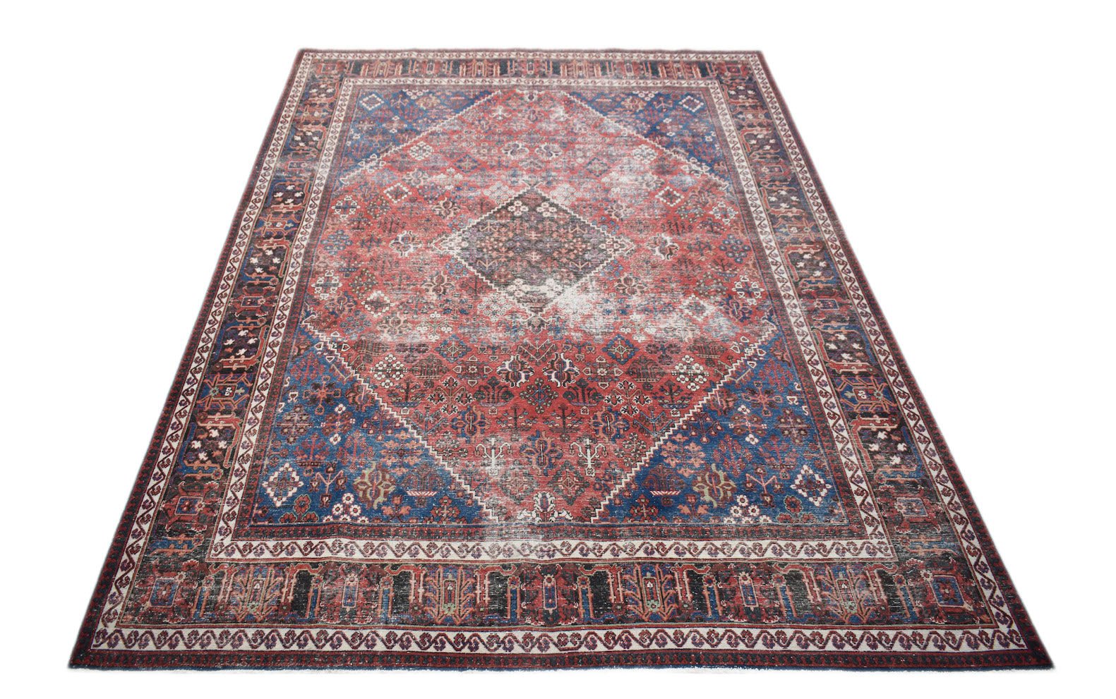 A vintage handwoven Persian Ghashghai rug featuring a distressed red and blue geometric pattern.
