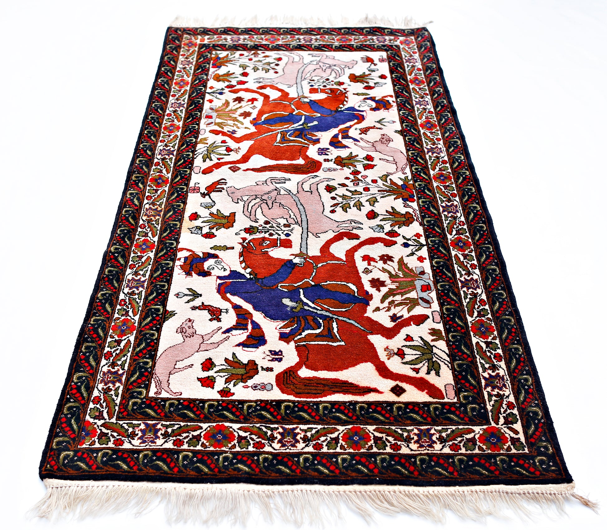 A vintage Persian rug featuring a detailed hunting scene with riders on horseback.