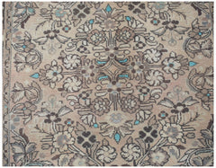 A vintage handwoven Persian rug featuring a floral pattern in muted tones with turquoise accents.