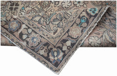 A handwoven vintage Persian rug featuring a faded floral pattern in muted earth tones.