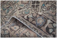 A handwoven vintage Persian rug featuring a faded floral pattern in muted earth tones.