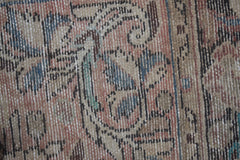 A close-up view of a vintage Persian rug featuring intricate floral patterns in muted tones.