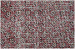A vintage Persian rug featuring a repeating geometric pattern in shades of red, cream, and black.