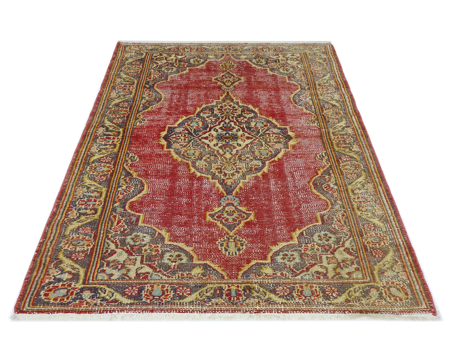 A vintage handmade Persian rug featuring a central medallion pattern in red, blue, and beige tones.
