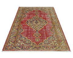 A vintage handmade Persian rug featuring a central medallion pattern in red, blue, and beige tones.