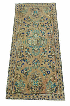 A vintage handmade Persian runner rug featuring a floral pattern in blue and tan tones.