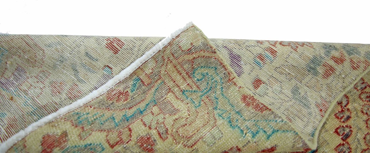A corner of a vintage handmade Persian rug showing its wool pile and cotton foundation.