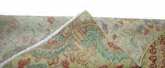 A corner of a vintage handmade Persian rug showing its wool pile and cotton foundation.