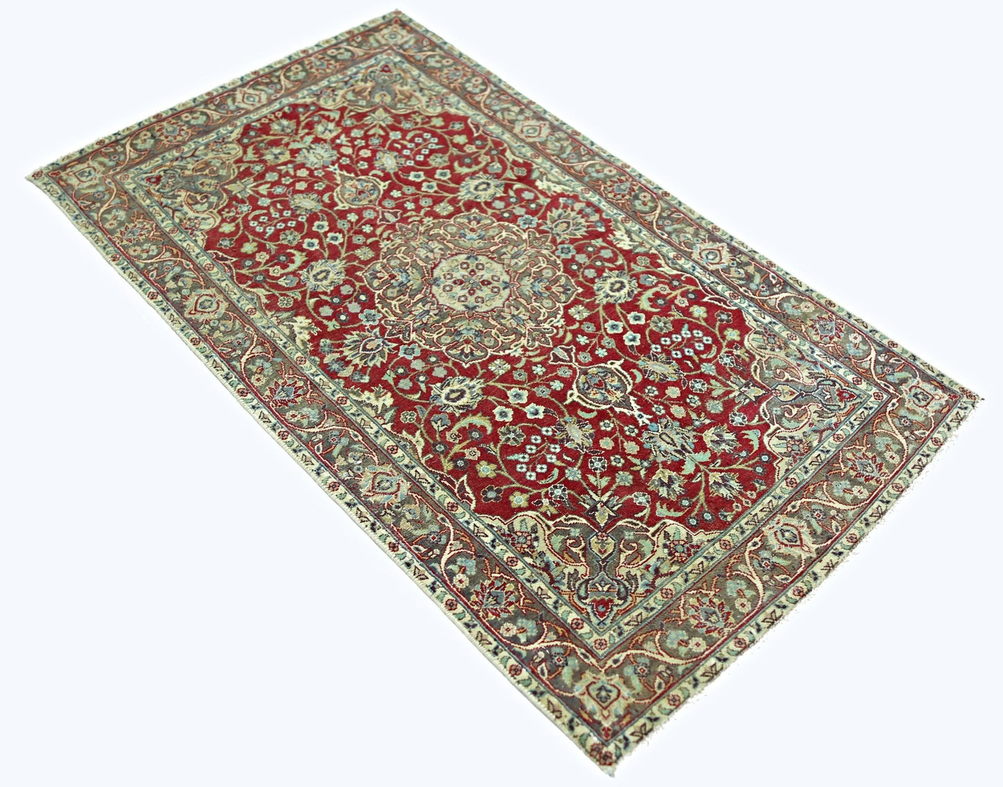 A rectangular vintage Persian rug featuring a red field with intricate floral patterns.