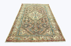 A rectangular vintage Persian rug featuring a geometric medallion pattern in muted earth tones.