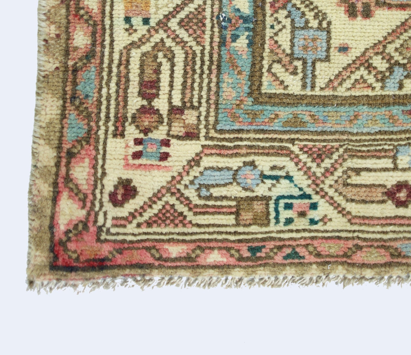 A corner view of a vintage handmade Persian rug featuring intricate geometric patterns in wool.