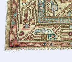A corner view of a vintage handmade Persian rug featuring intricate geometric patterns in wool.