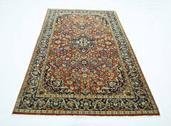 A rectangular vintage Persian rug featuring an intricate floral pattern in red, blue, and cream.