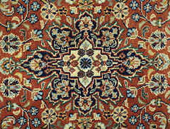 A vintage Persian rug featuring a detailed floral medallion pattern in shades of red, blue, and cream.