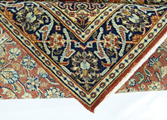 A folded vintage Persian rug featuring intricate floral patterns in blue, red, and cream tones.