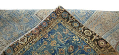 A corner of a vintage Persian rug folded over to show its blue and brown patterned wool pile.