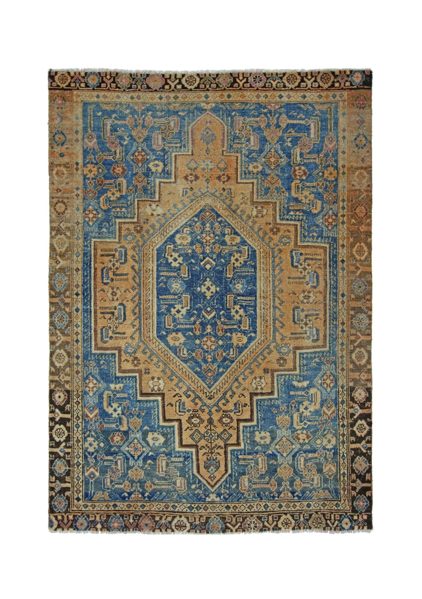 A vintage handmade Persian rug featuring a central geometric medallion in blue and tan tones.