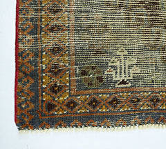 A corner view of a vintage handmade Persian wool rug featuring intricate geometric patterns.