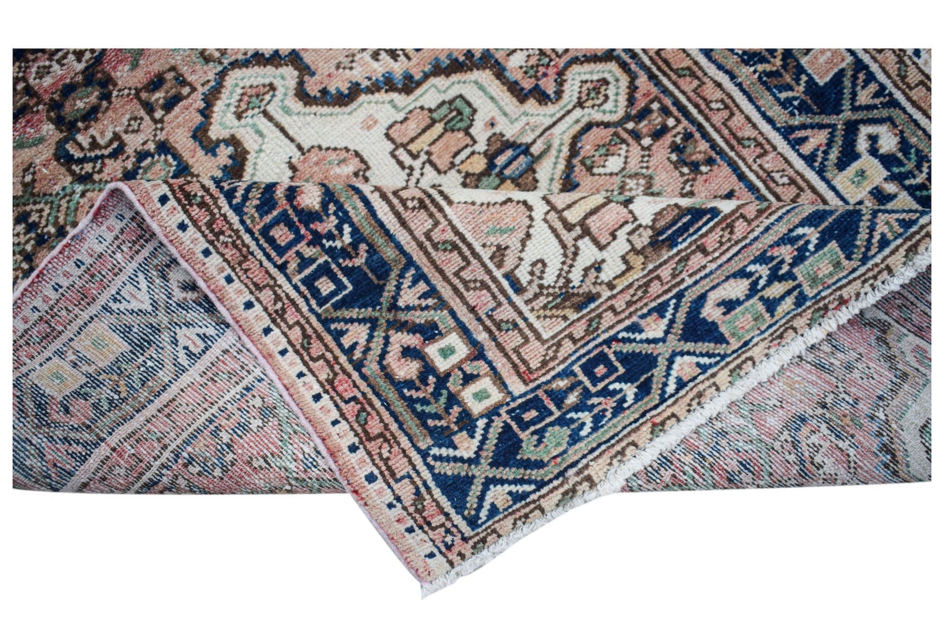 A handwoven vintage Persian rug featuring a floral pattern in blue, pink, and cream tones.