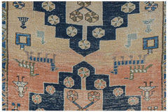 Vintage Persian rug with geometric patterns in blue, peach, and beige.