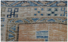 Vintage Persian rug with geometric patterns in blue, brown, and tan.